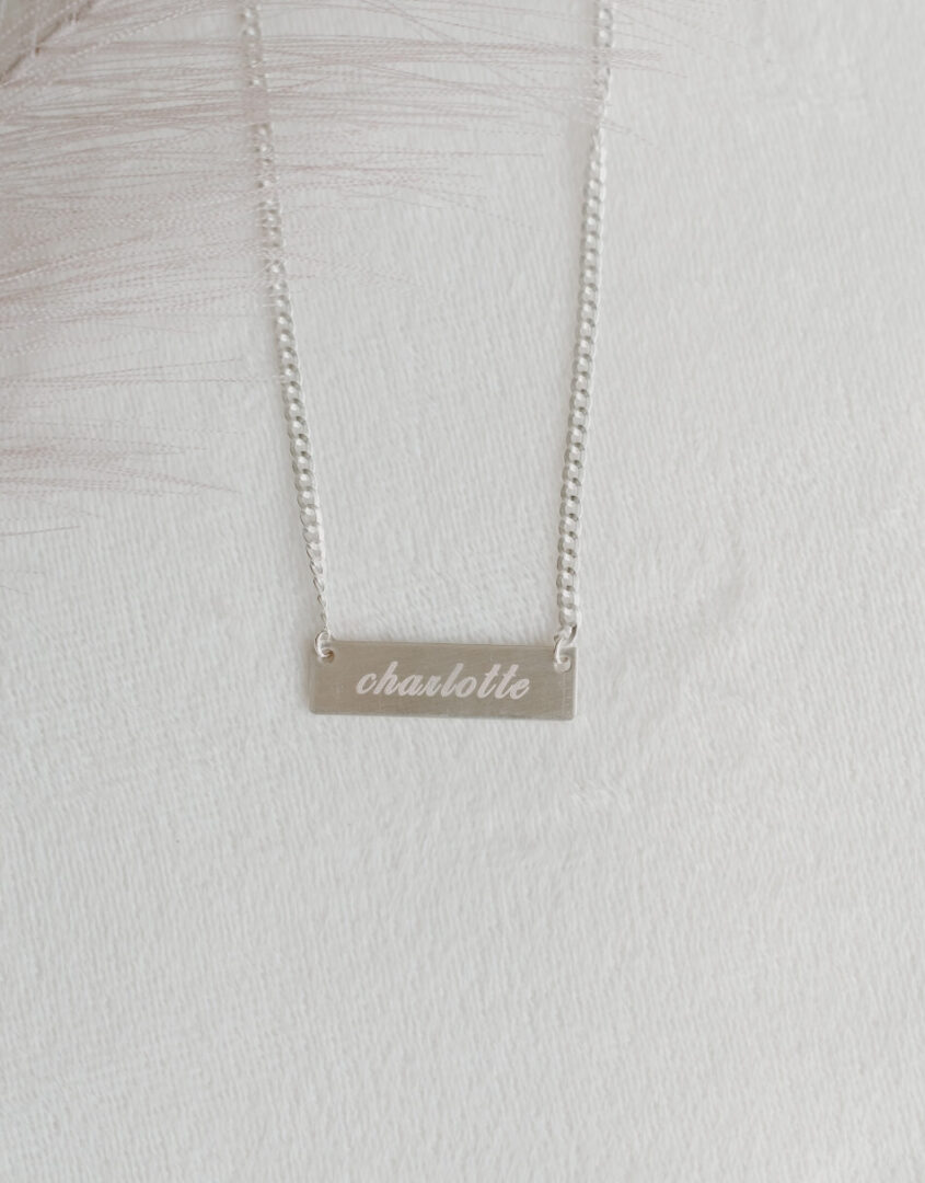 Flatlay Image of Engraved Sterling Silver Name Bar Necklace
