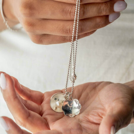 Best personalized necklace for a mom of 2. A flower and a circle charm with names hand stamped