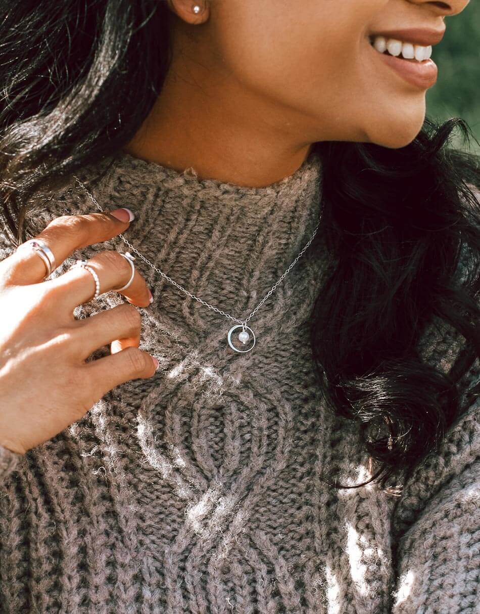 women wearing necklace with pearl drop