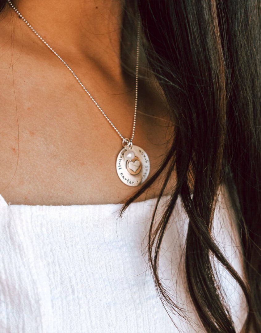 Golden necklace with heart and names stamped on it