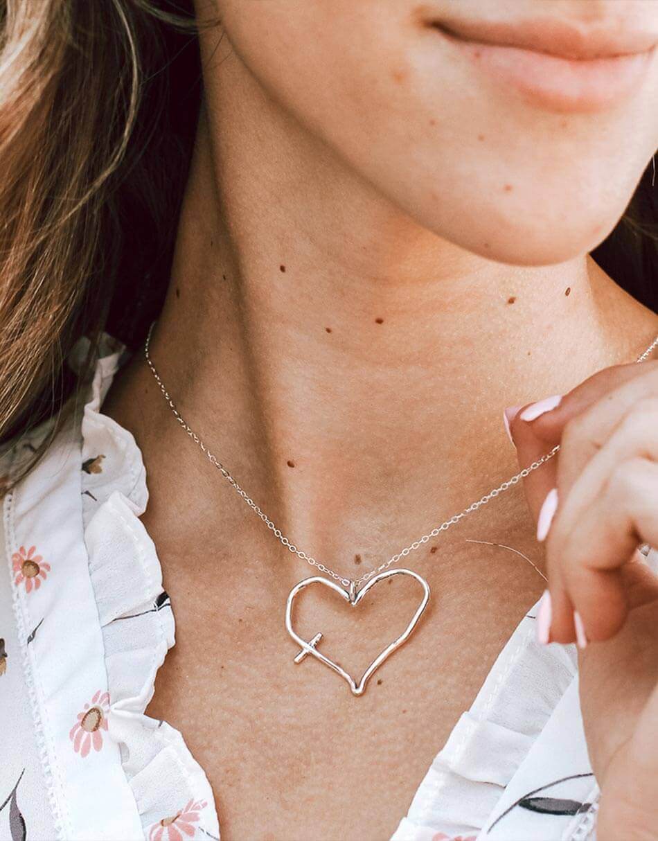 An imperfect heart hand forged in sterling silver and hung on a sterling silver chain. Perfect cross necklace for women