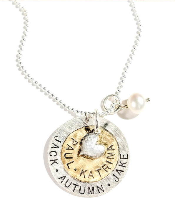 A large sterling silver disc layered with a brass disc and topped with a silver heart. Hand stamped jewelry gift for mom, grandma