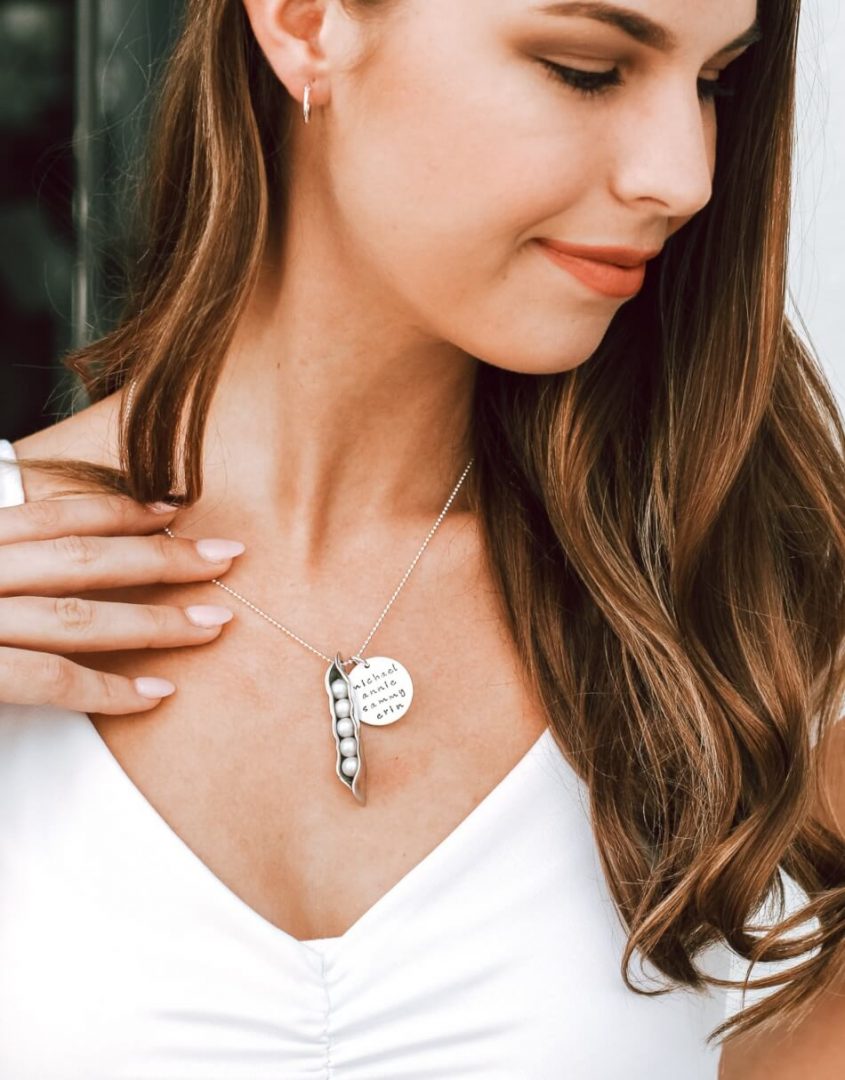 A mother wearing a 5 peas in a pod necklace with names of children and family member. This is one of the best necklace for mothers