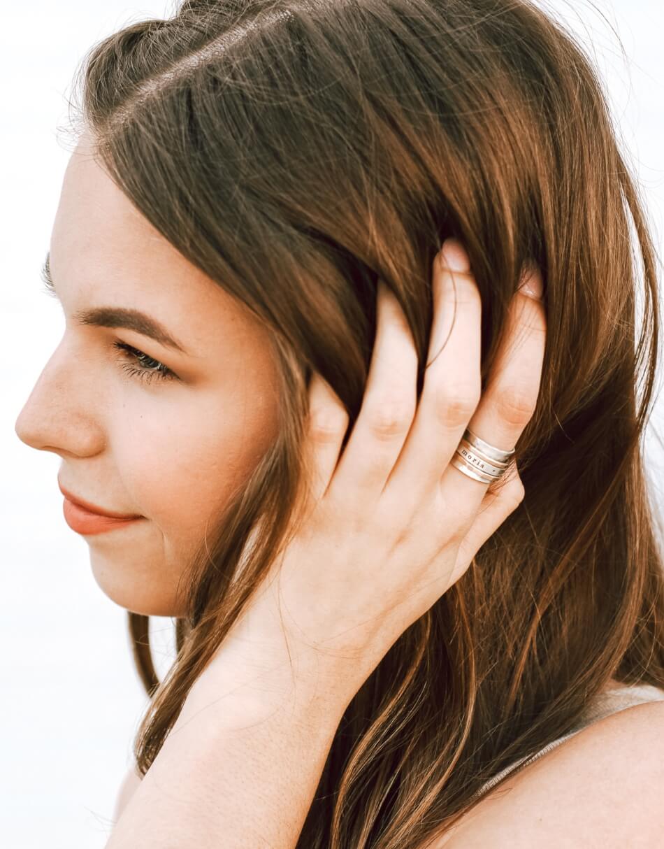 a girl wearing a Spinner ring with names of loved ones hand stamped on it